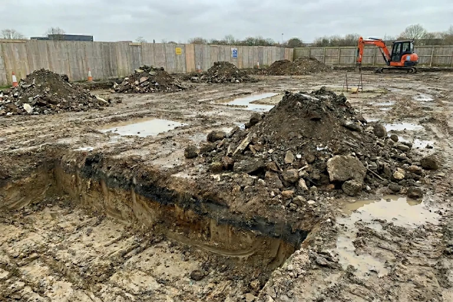 Multiple grab-hire scale spoil piles at a brownfield regeneration site, hired through Skyward Skip Hire